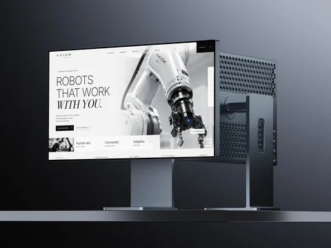AXIOM-concept op een desktopmonitor: een robotarm naast de Engelstalige kop Robots that work with you.