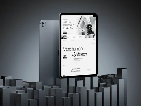AXIOM-homepage op een staande tablet, van de robotarm in de hero naar de boodschap More human. By design.