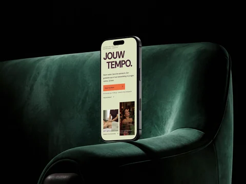 Telefoonmockup van de RELA-homepage op groen textiel, met de bezoekactie Boek The Reset.