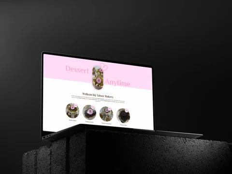 Taloor Bakery-homepage op een laptop boven donkere betonblokken, met de roze Dessert Anytime-presentatie.