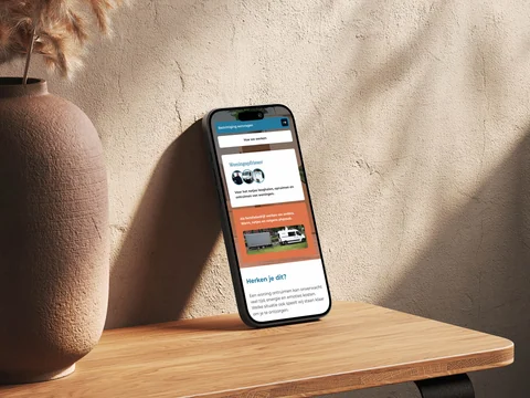 Telefoon naast een vaas met de bedrijfsintroductie van Woningopfrisser.