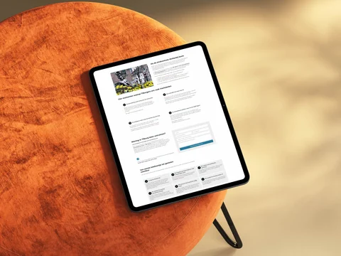Staande tablet op een oranje poef met uitleg over woningontruiming in Tilburg.