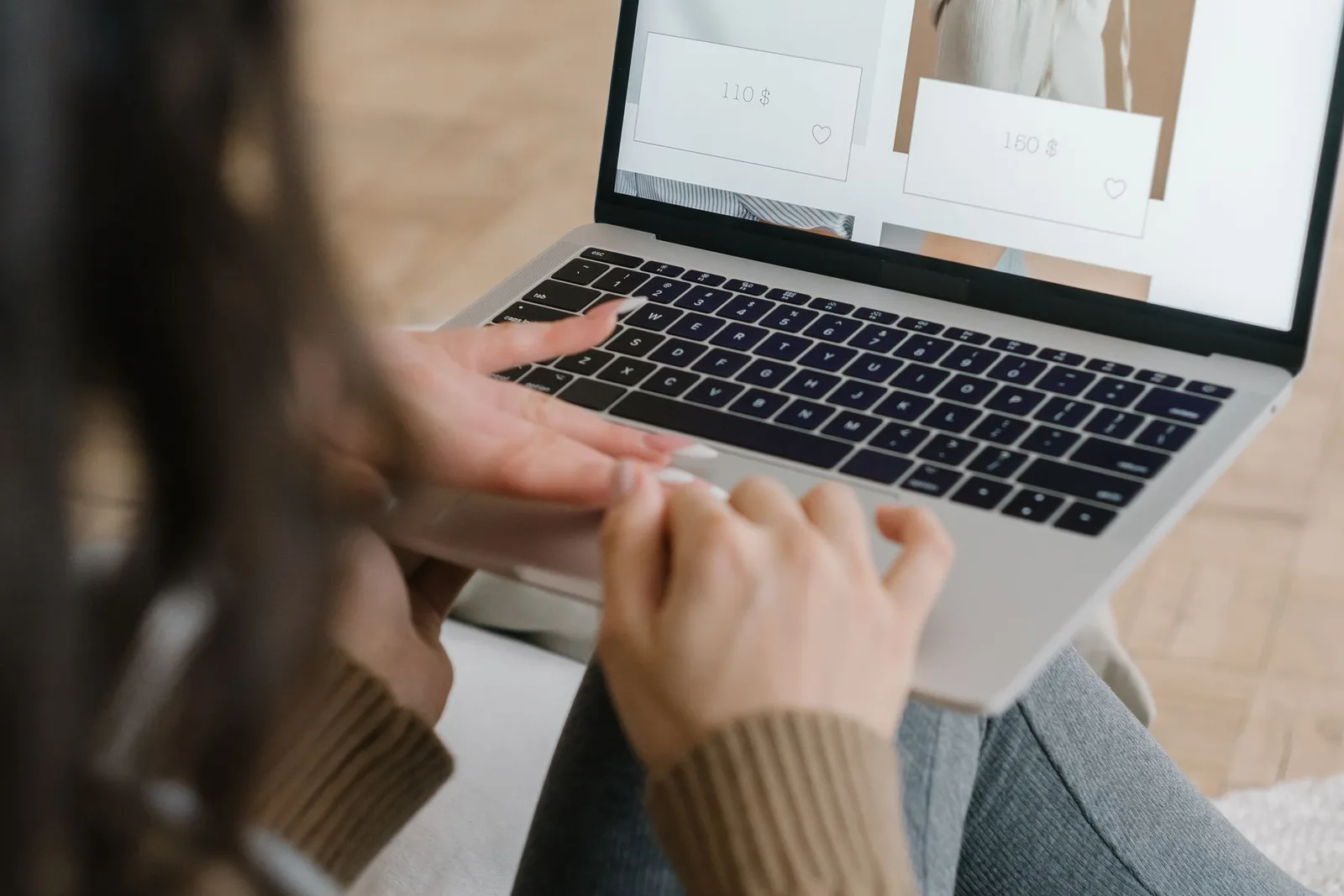 Een bezoeker bekijkt kleding in een online fashionwinkel op een laptop.