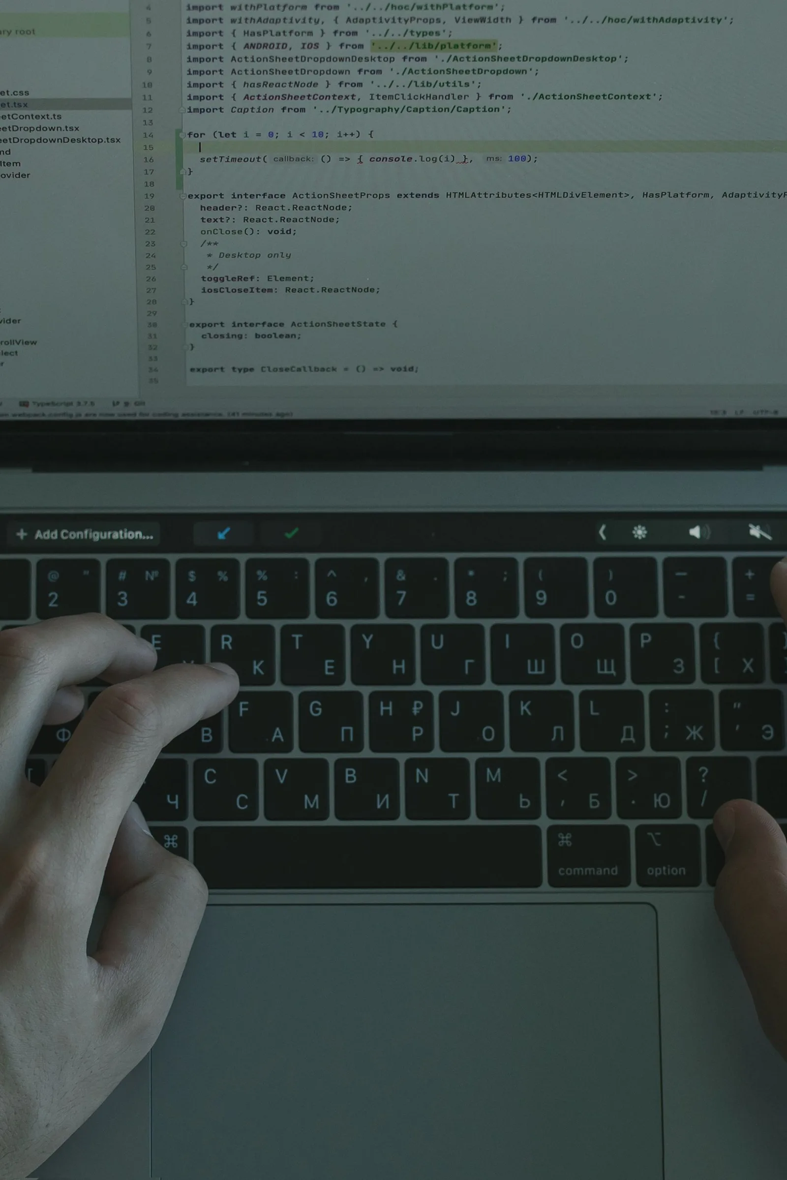 Handen typen code op een laptop.