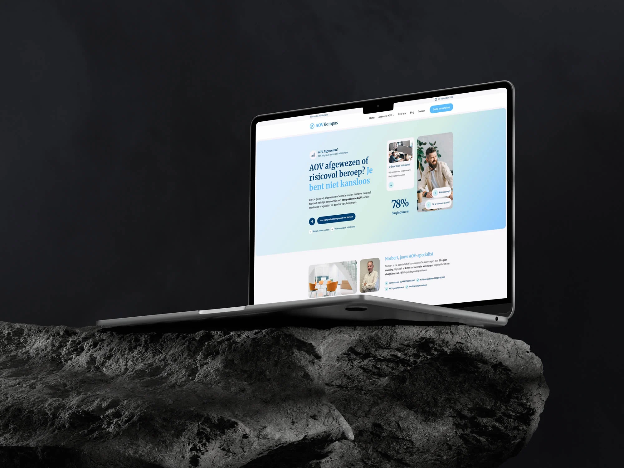 Laptop op een donkere rots met de homepage van AOV Kompas.